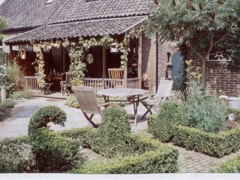 Overdekte veranda die aansluit op een terras van gebakken klinkers