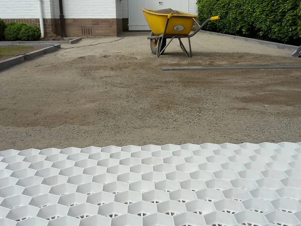 Grindoprit met scherpe kanten langs een gesnoeide haag