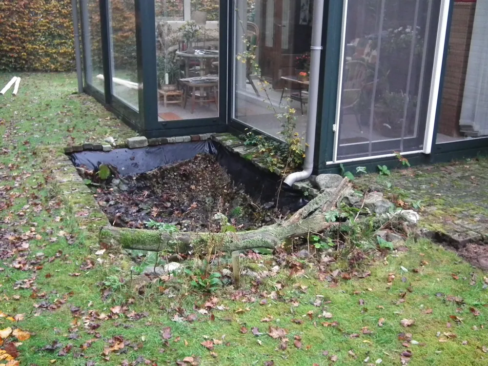Vijverpartij langs een tuinkamer, tijdens het najaarsonderhoud