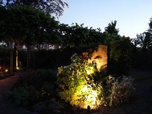 Dezelfde folly bij avond, uitgelicht met warme spots
